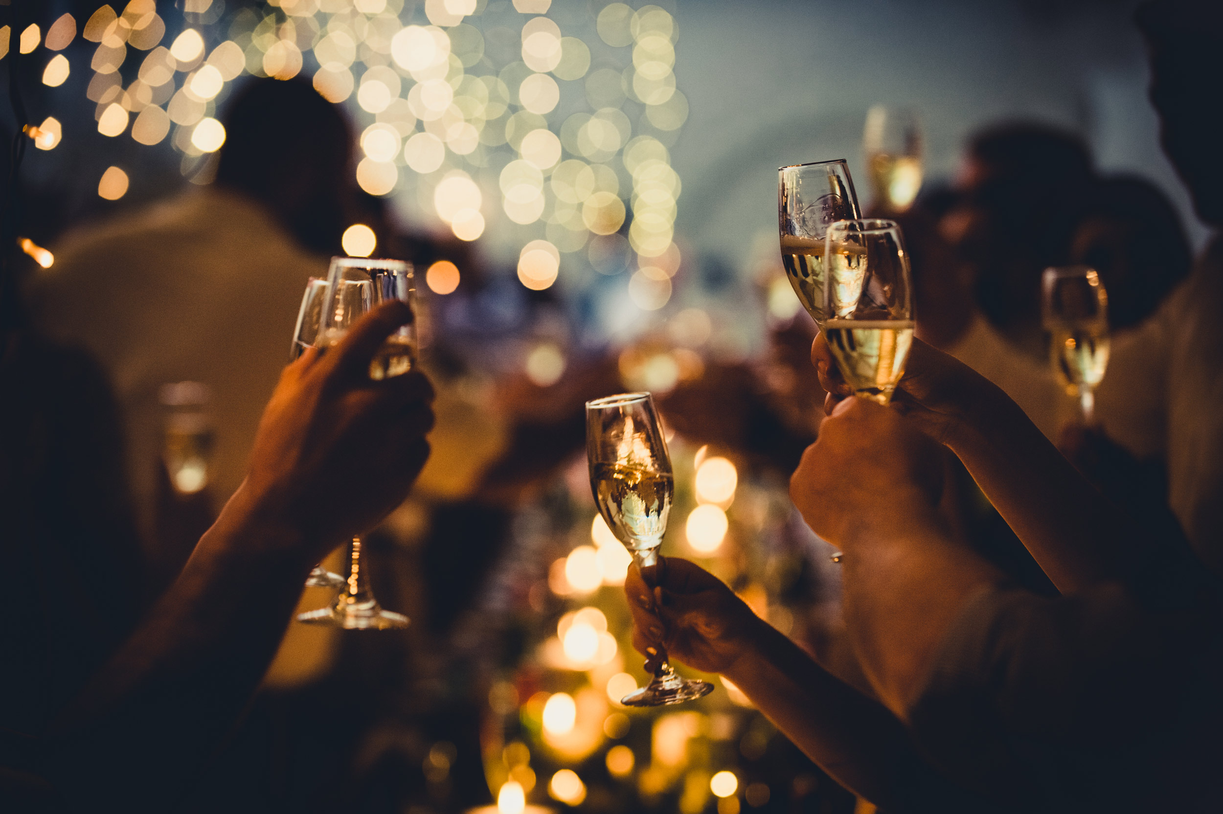 Late night party, people holding glasses of Prosecco